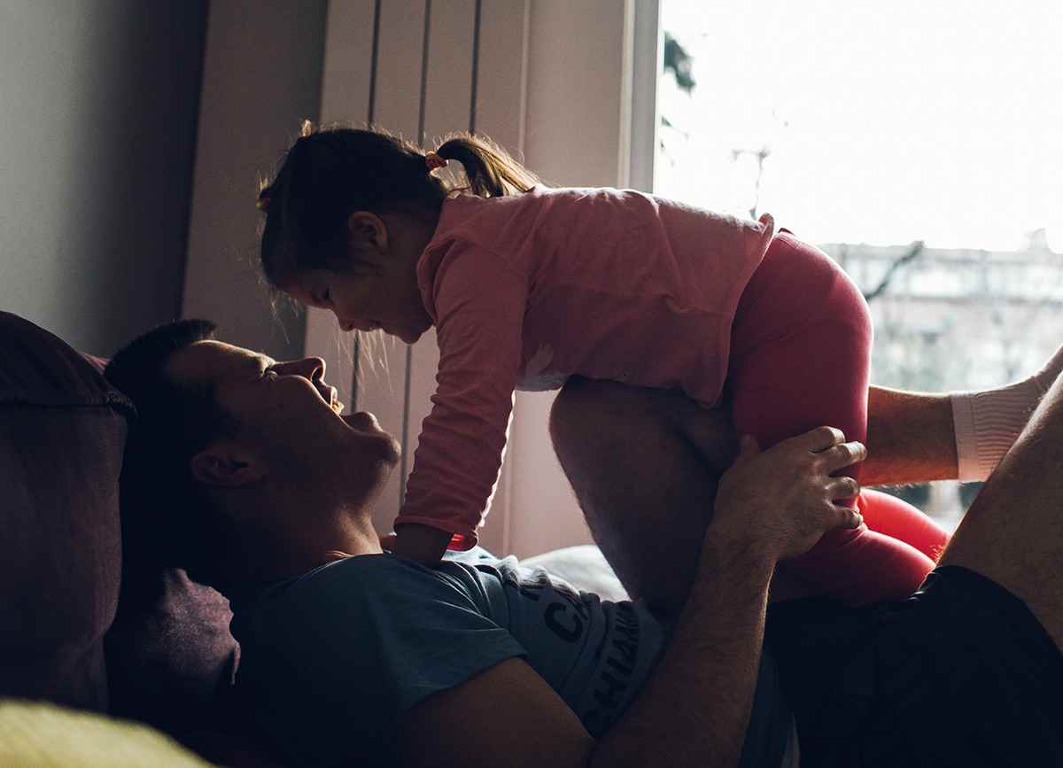 Nera's dad lifts her up as they play and laugh together in Bosnia and Herzegovina.