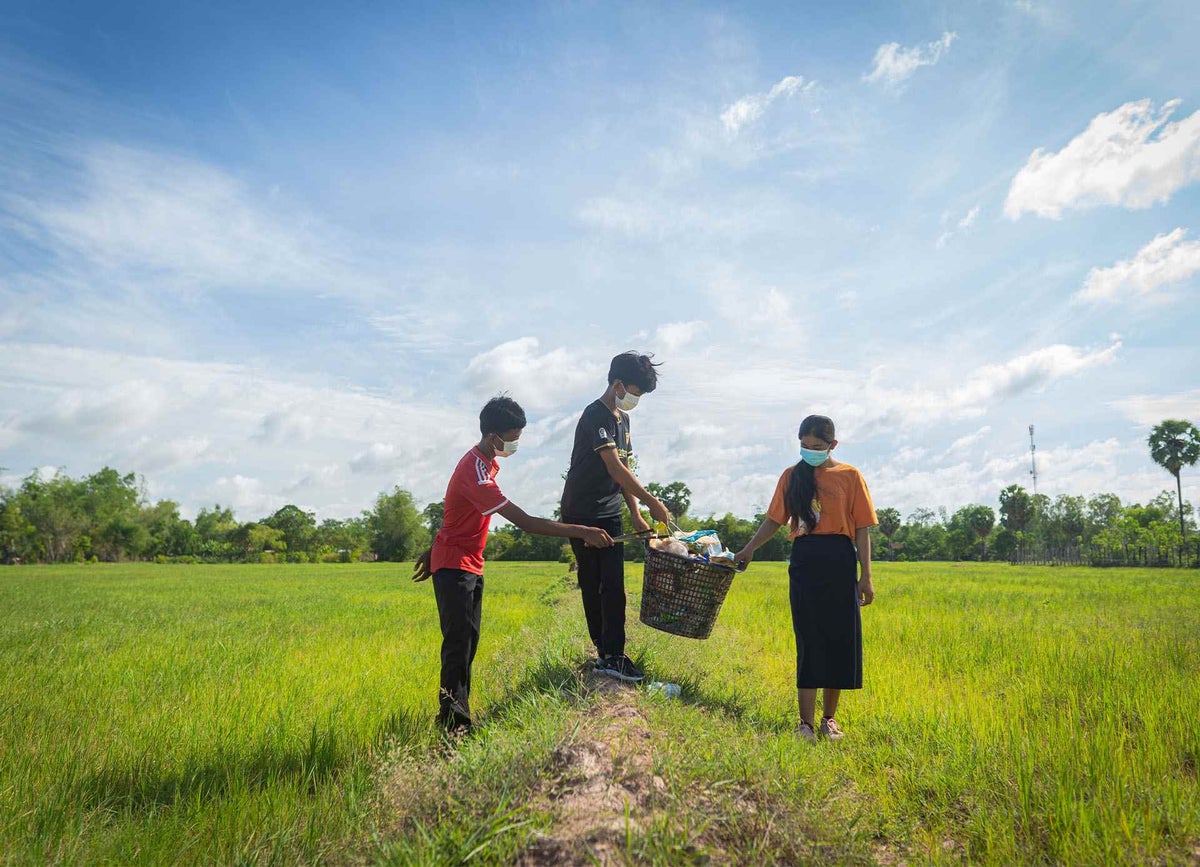 Grade 9 students from a local lower secondary school in the Siem Reap province pick up rubbish from the rice fields around their village