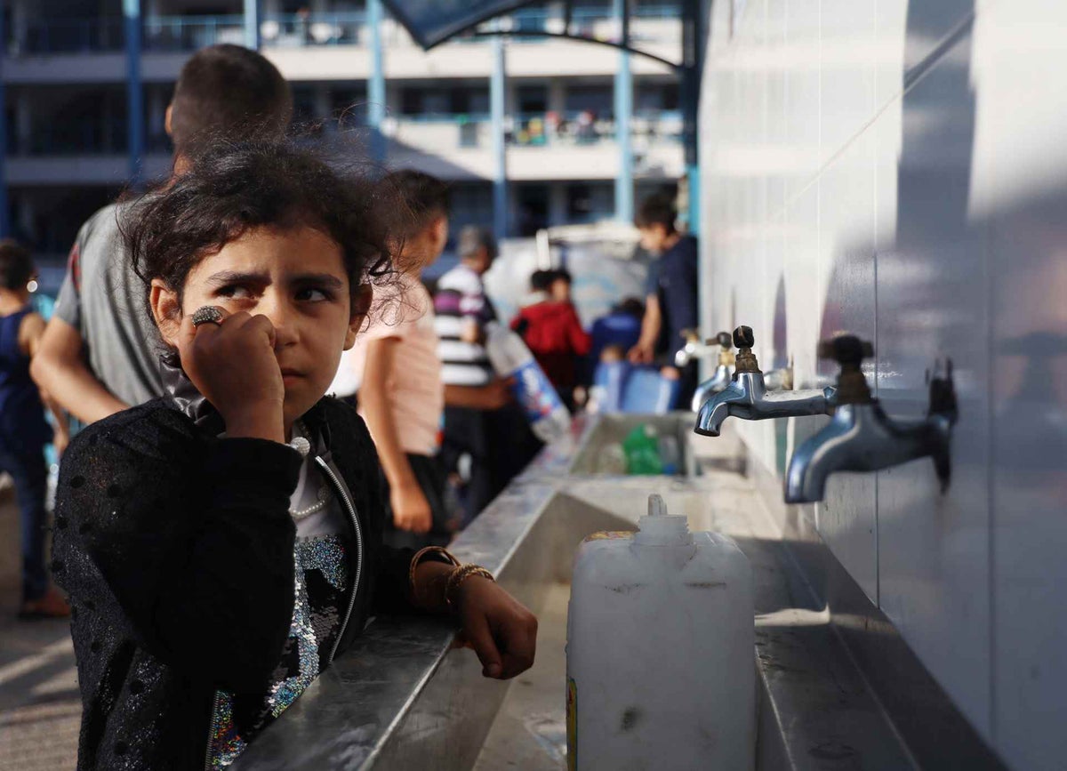 A Palestinian girl fills a jerrycan with clean drinking water.