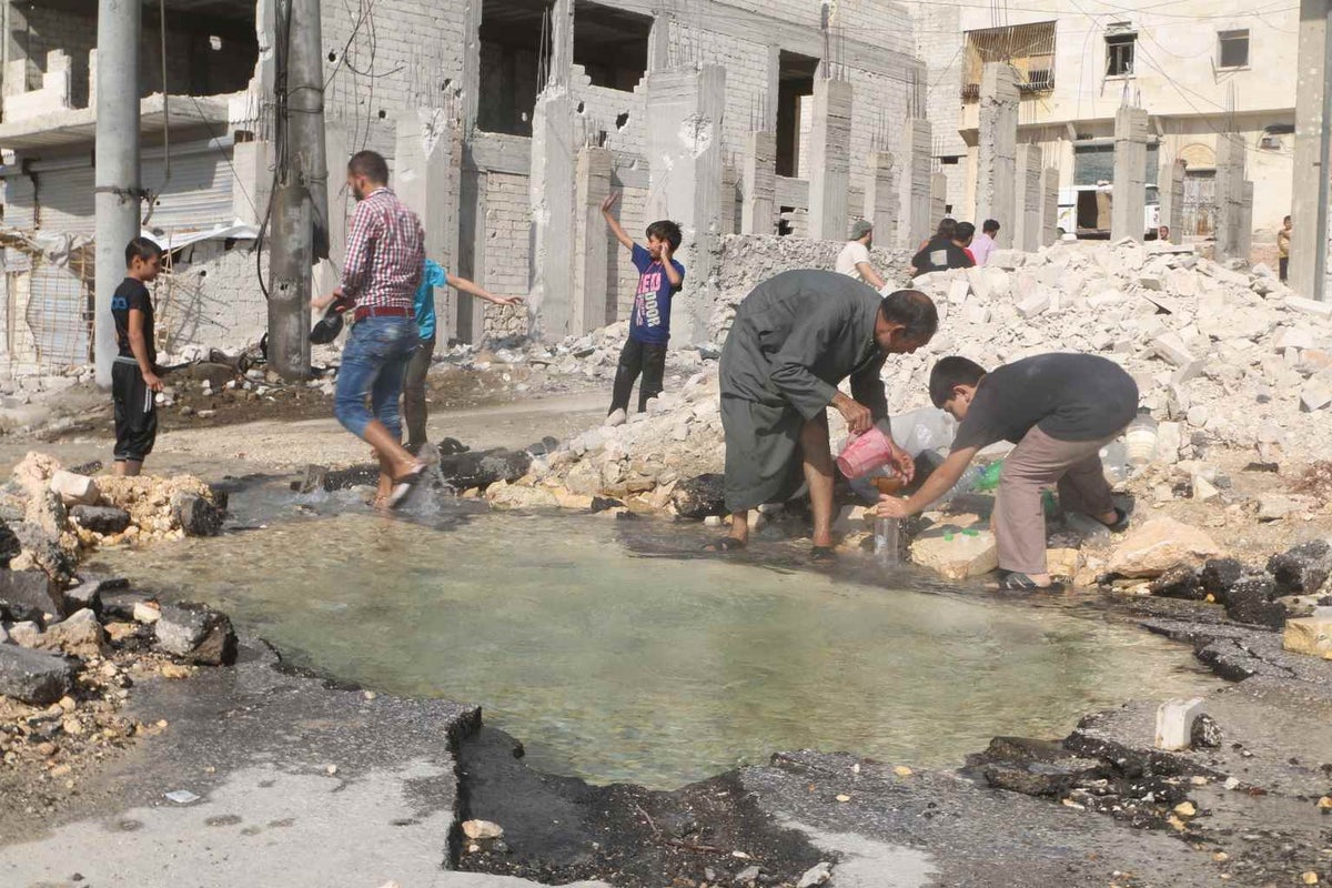 a boy and his father fill up bottles of water that collected in a bomb crater after shelling in Aleppo. The health risks of unsafe water sources are countless - especially for children. 