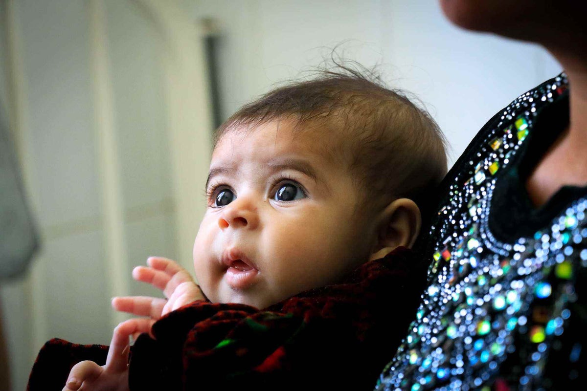 Mum holding baby, diagnosed with malnutrition