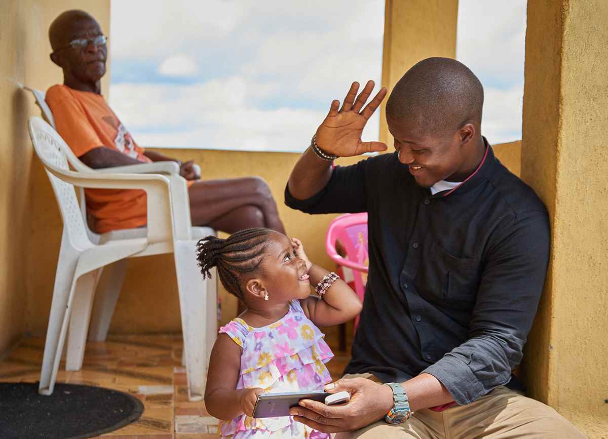 John Terry plays with a phone with his daughter, Joan, in Sierra Leone.