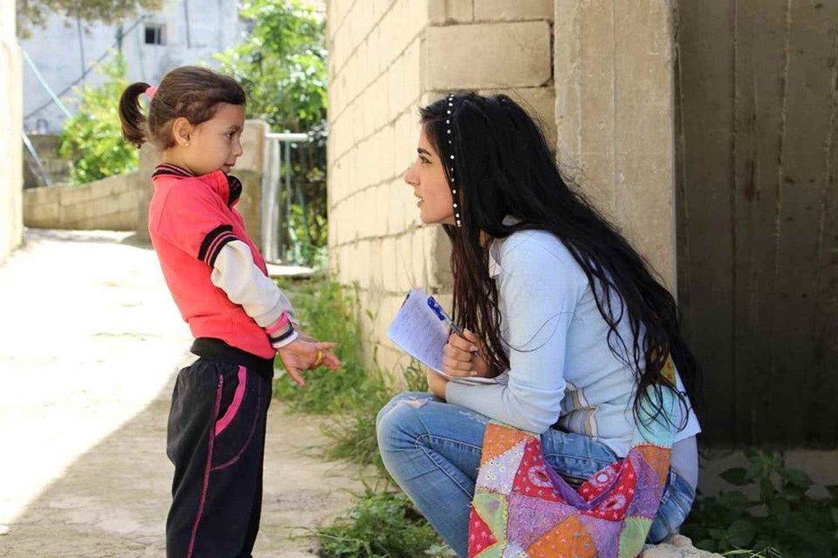 Hiba talks to a small child.