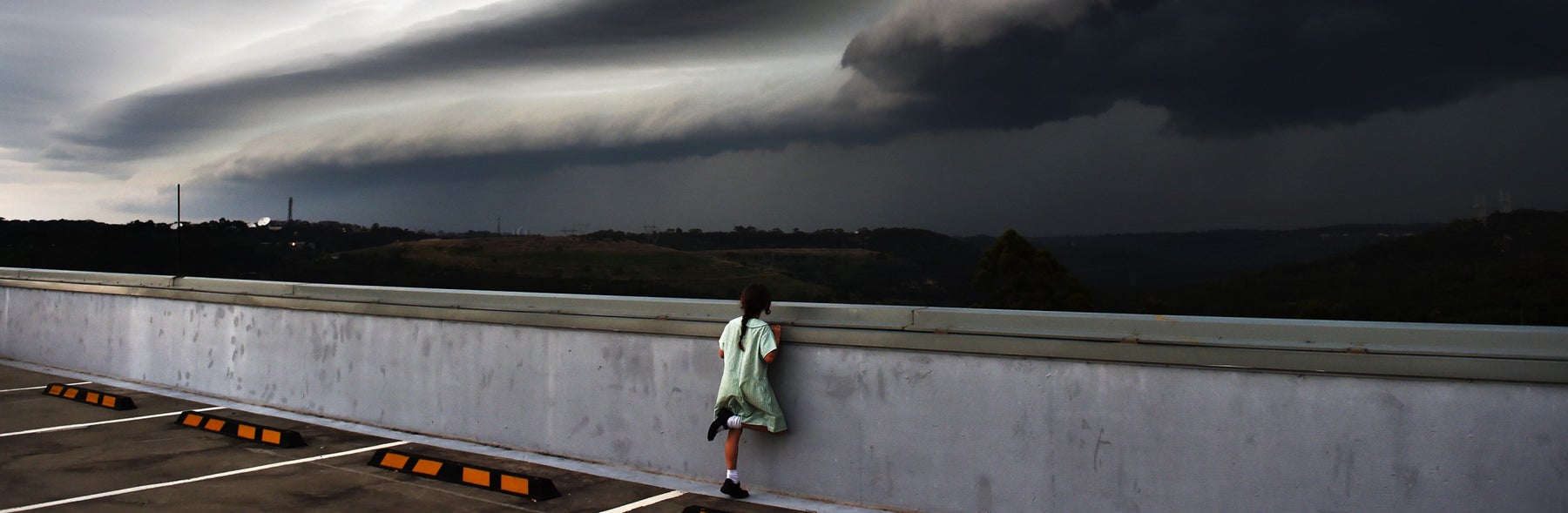 Young girl looking out into the distance with a storm coming in