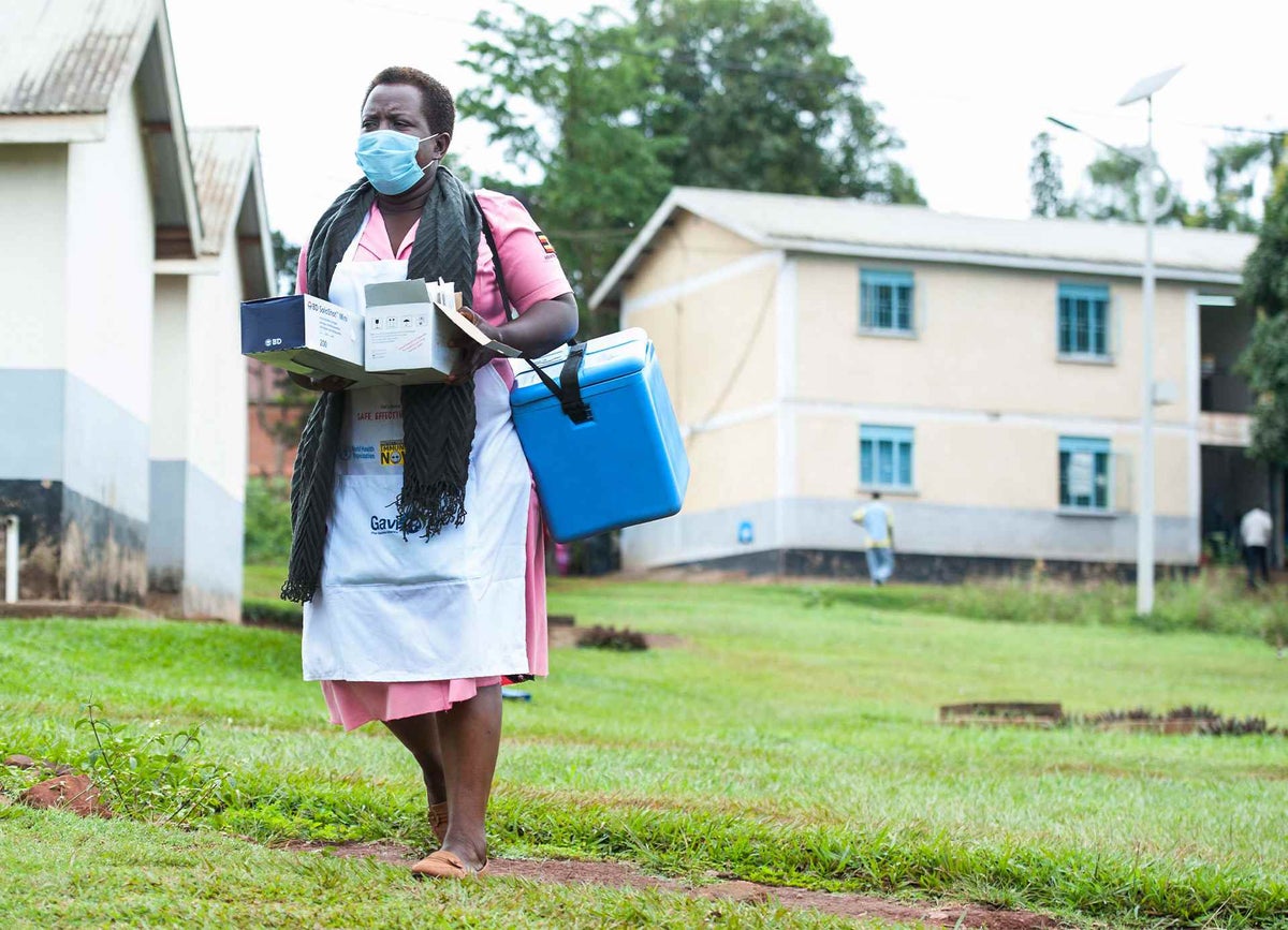 Nurse walking with cold box of vaccines. 
