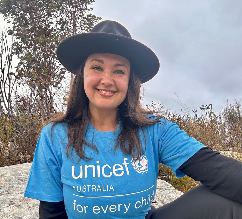 Rae Johnston smiling at the camera wearing a UNICEF Australia shirt.