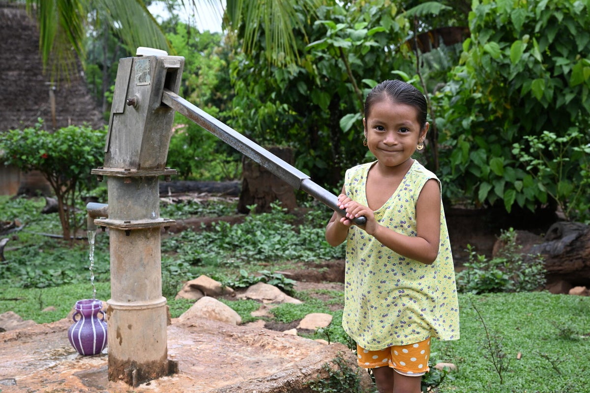 A girl collects from a tap in Belize.