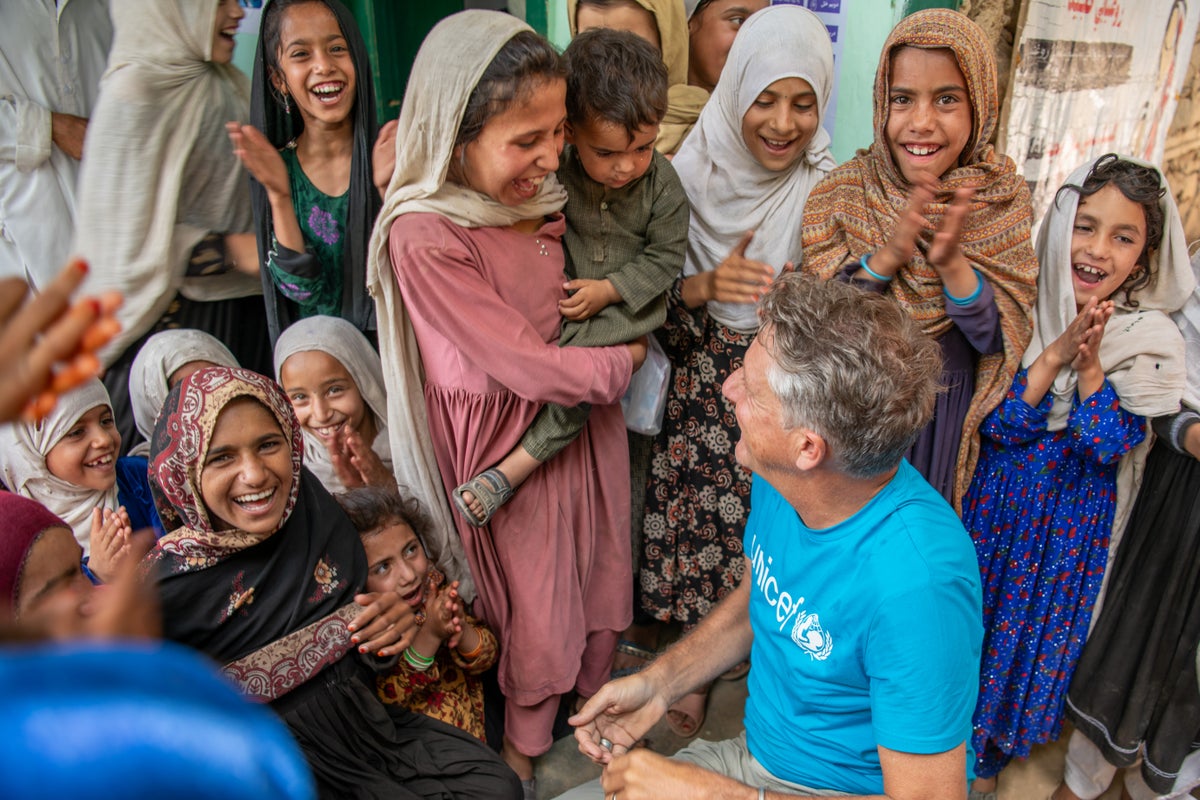 A group of children with an adult humanitarian worker