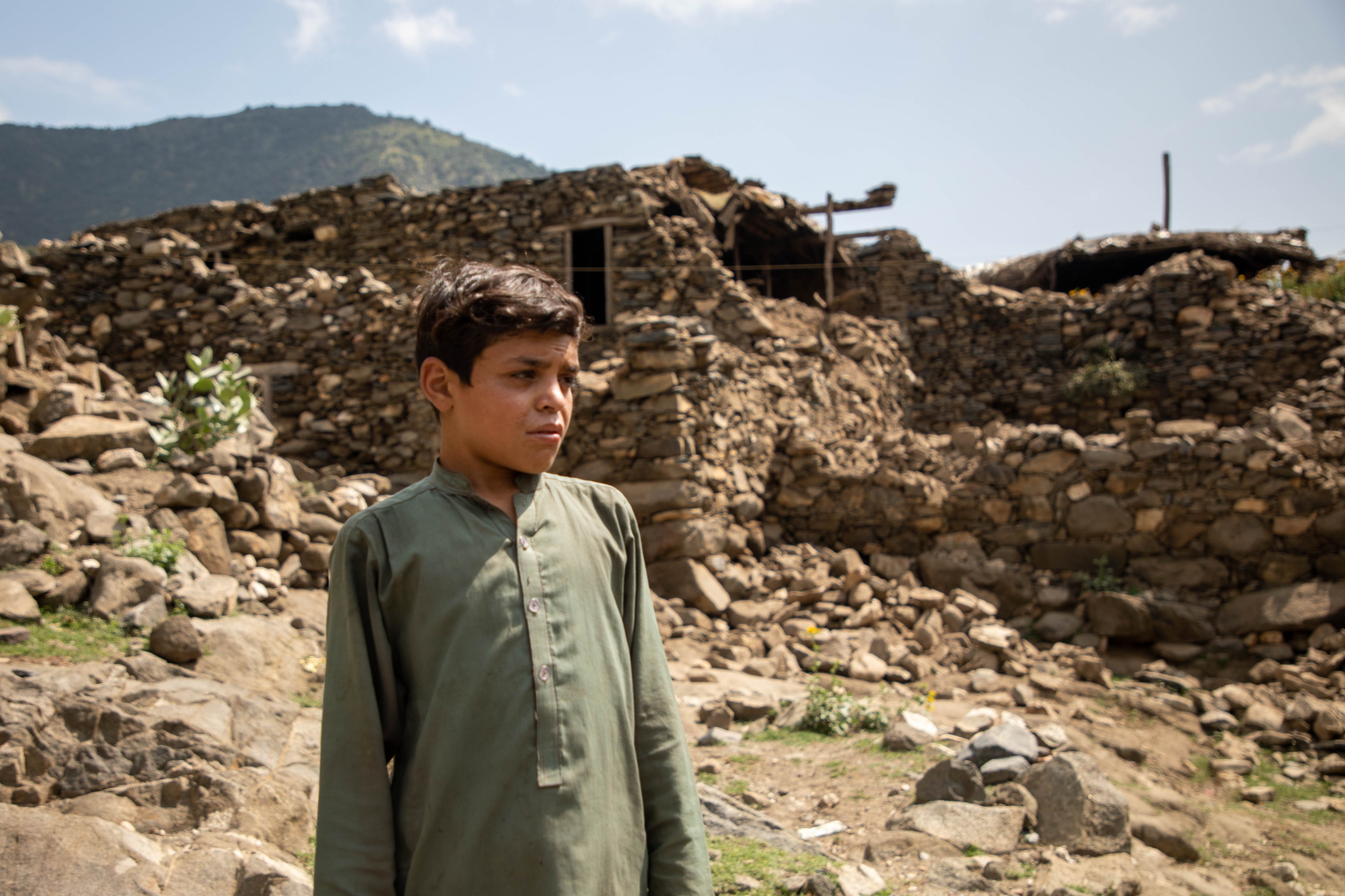 A young boy stands among the ruins of a village after the August earthquake in Afghanistan.