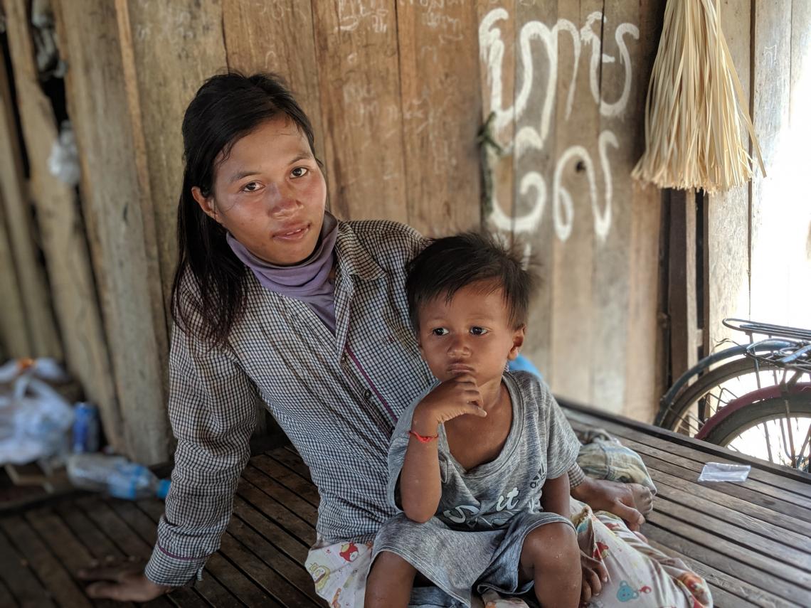 Mother and child sitting in a hut. 