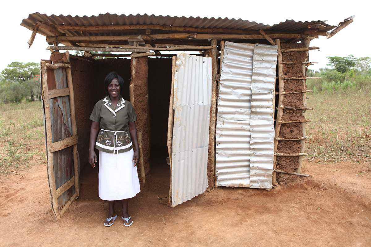 Alice Ndolo stands by her laterine in Nduru Village, which has been certified as Open Defecation Free since January 2015