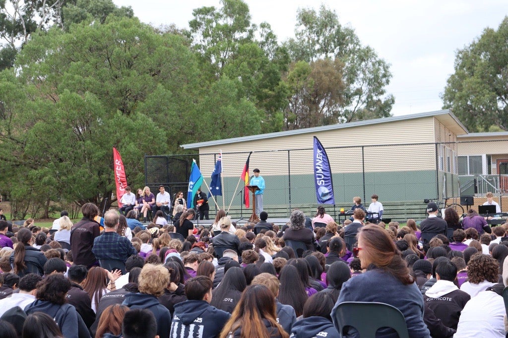 UNICEF Australia Young Ambassador Todd stands at a podium giving an address at a high school in Victoria.