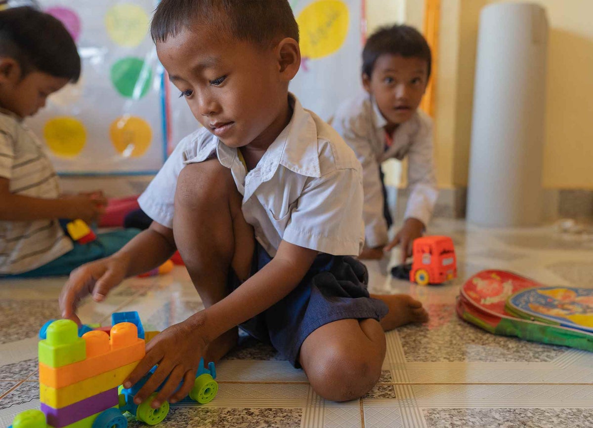 A boy plays with a train made from Lego bricks during a classroom break at his primary school in Cambodia