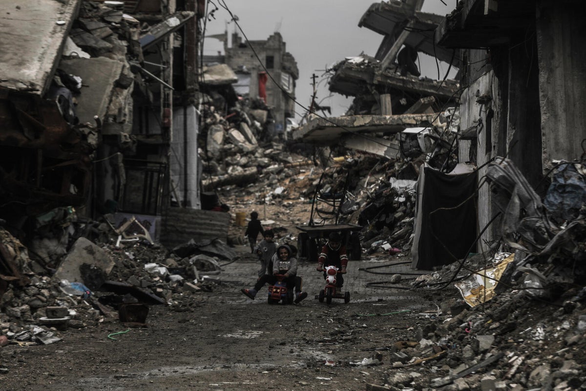 Children playing in the streets of Gaza surrounded by destroyed buildings.