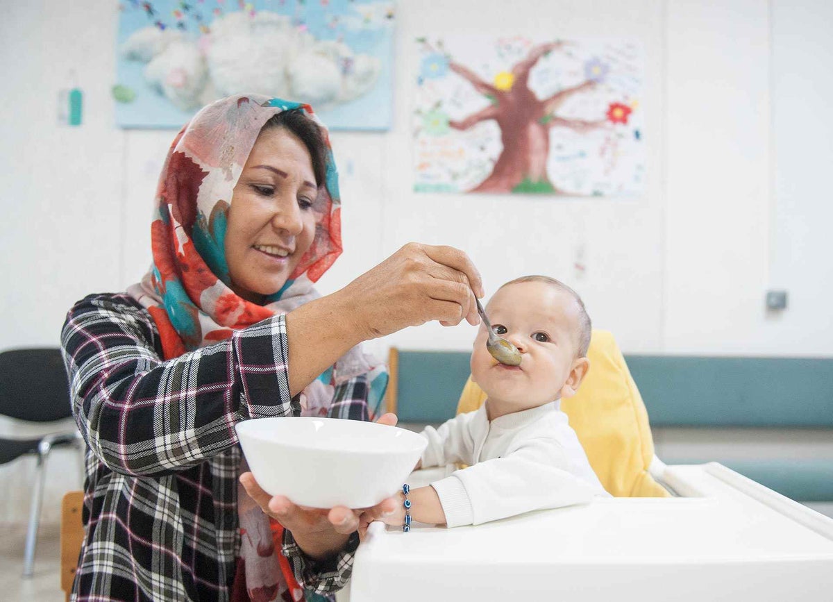 Refugee mother feeding her baby at ADRA community centre in Belgrade.