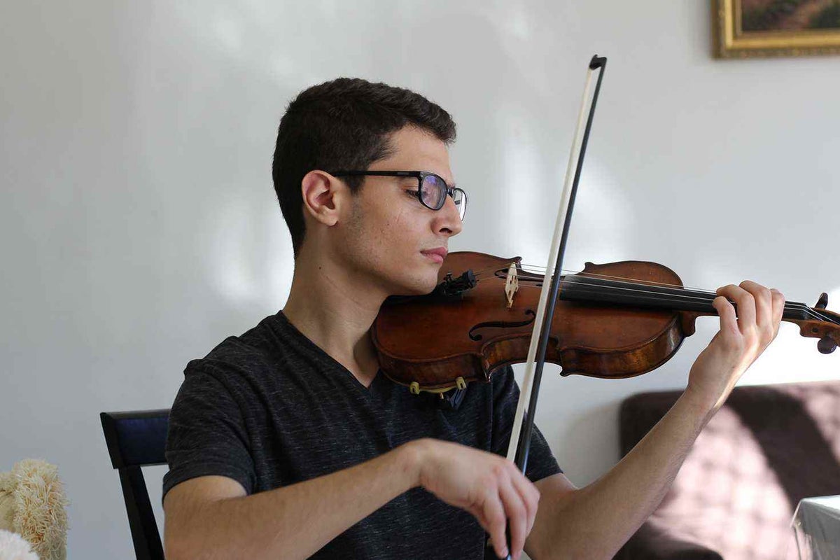 Aboud plays his 19th century violin at his home in Sydney.