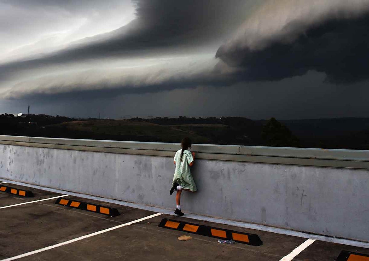 Child looks out towards a brewing storm