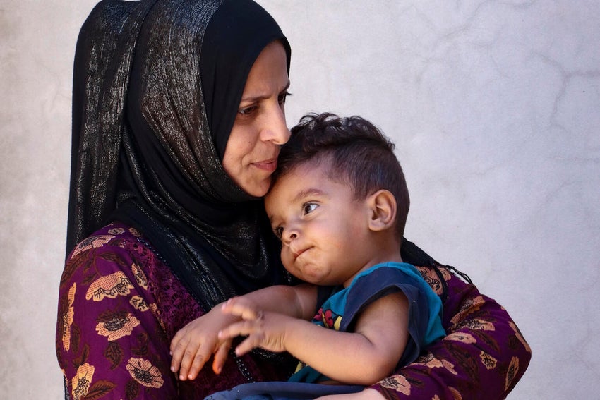 A Syrian mother and child hugging each other.