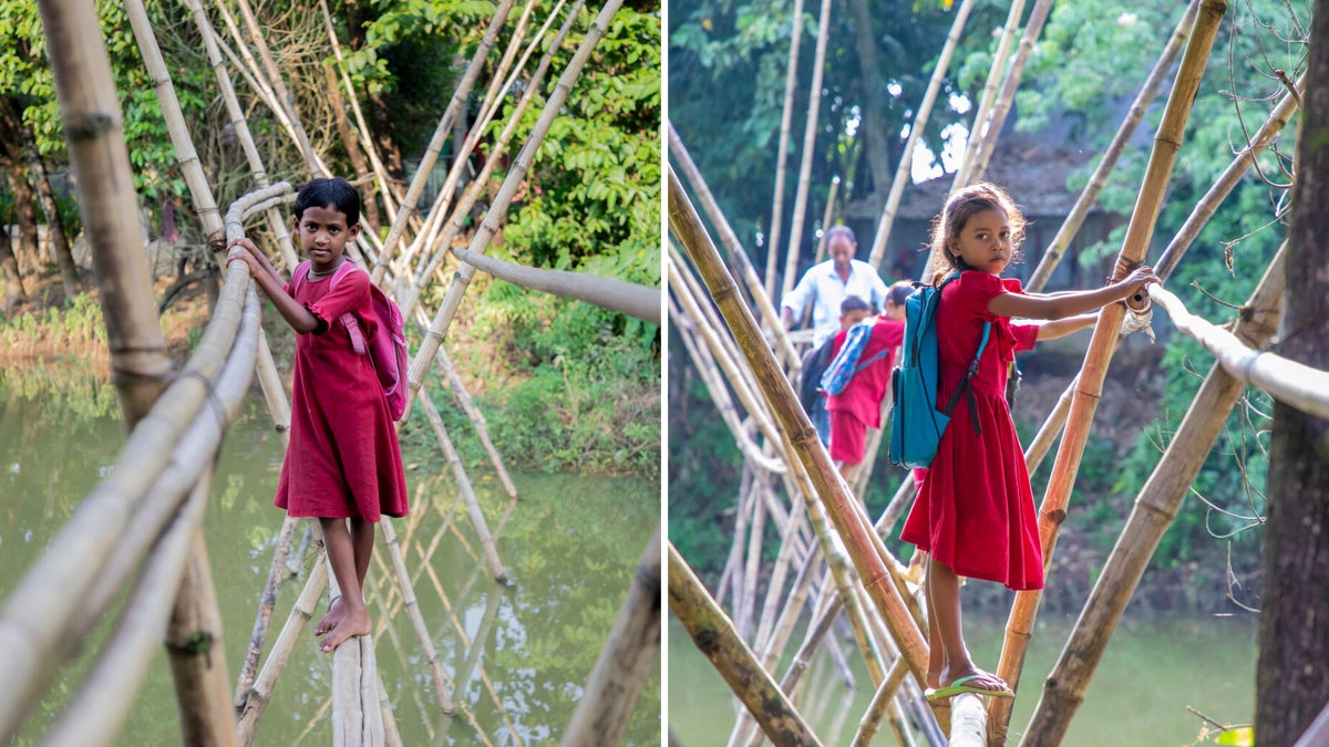 Two girls walking along a thin wooden bridge to get to the other side of the river