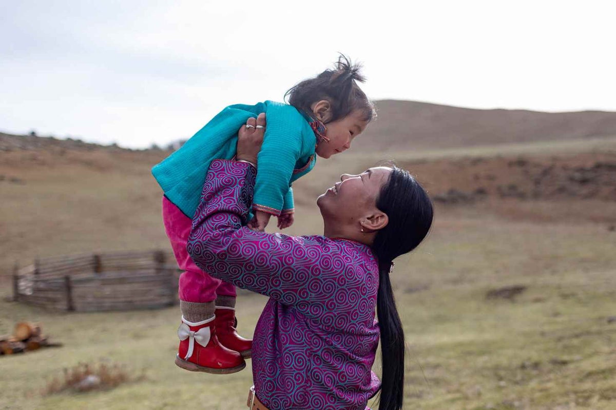 Sugarmaa, 1, is held by her mother, Delgermurun, 33, near their ger (nomadic tent) in the Khövsgöl Province, Mongolia