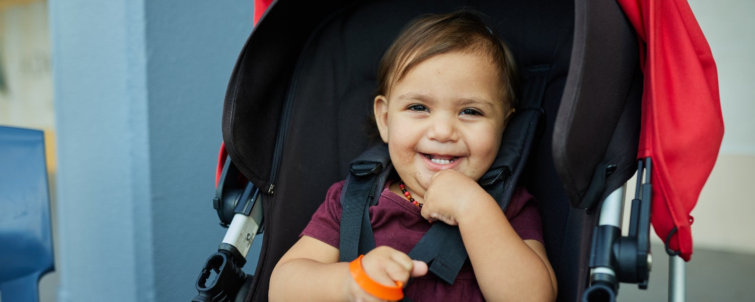 A smiling child in a pram