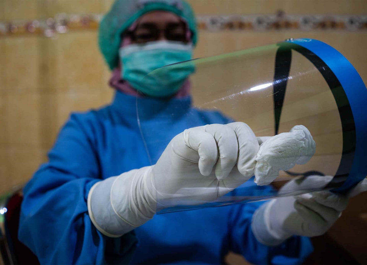 A midwife cleaning her face shield