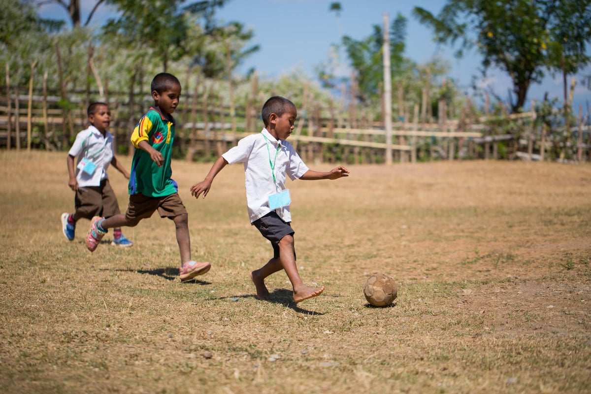 Students playing soccer in their break from school work