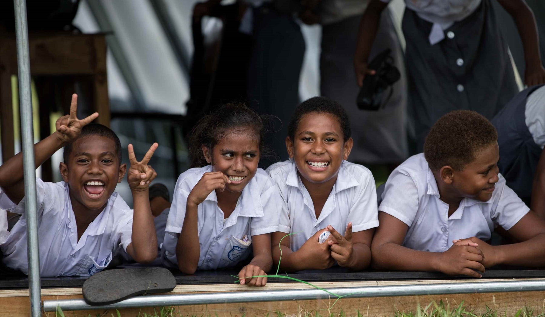 School children in Fiji outside a portable school tent. It's their first day back at school after a cyclone destroyed their school.