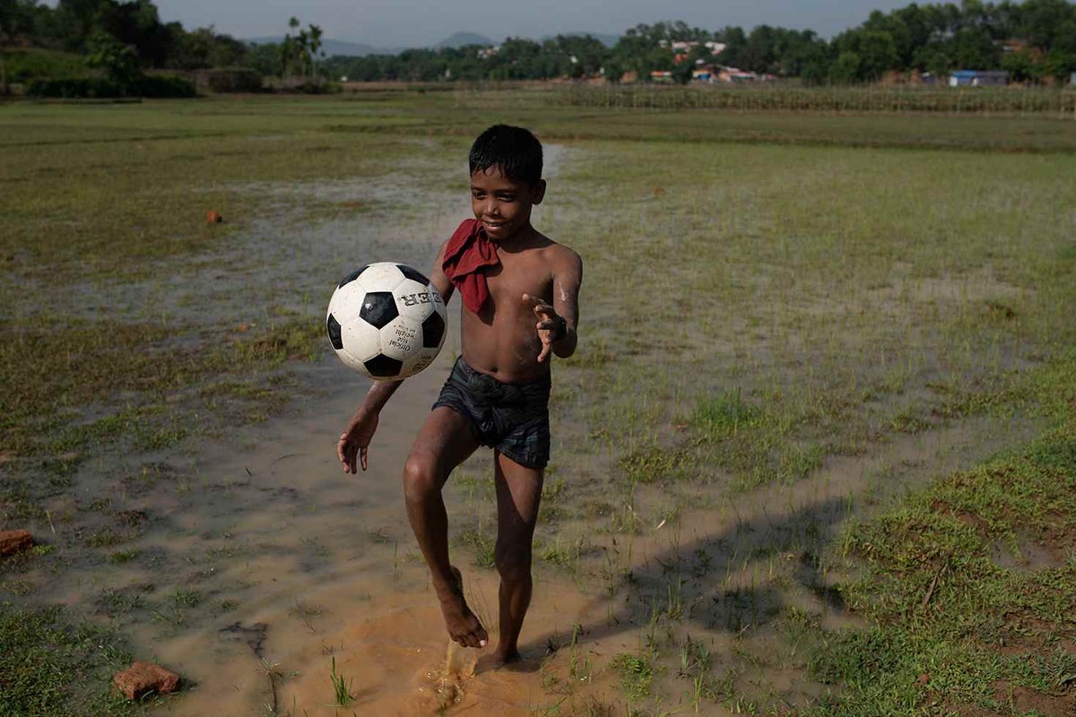 Boy plays with soccer ball in field.
