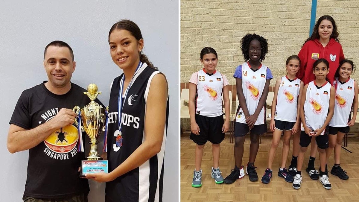 A young woman holding a trophy and also standing next a to a group of young basketball players on a basketball court. 