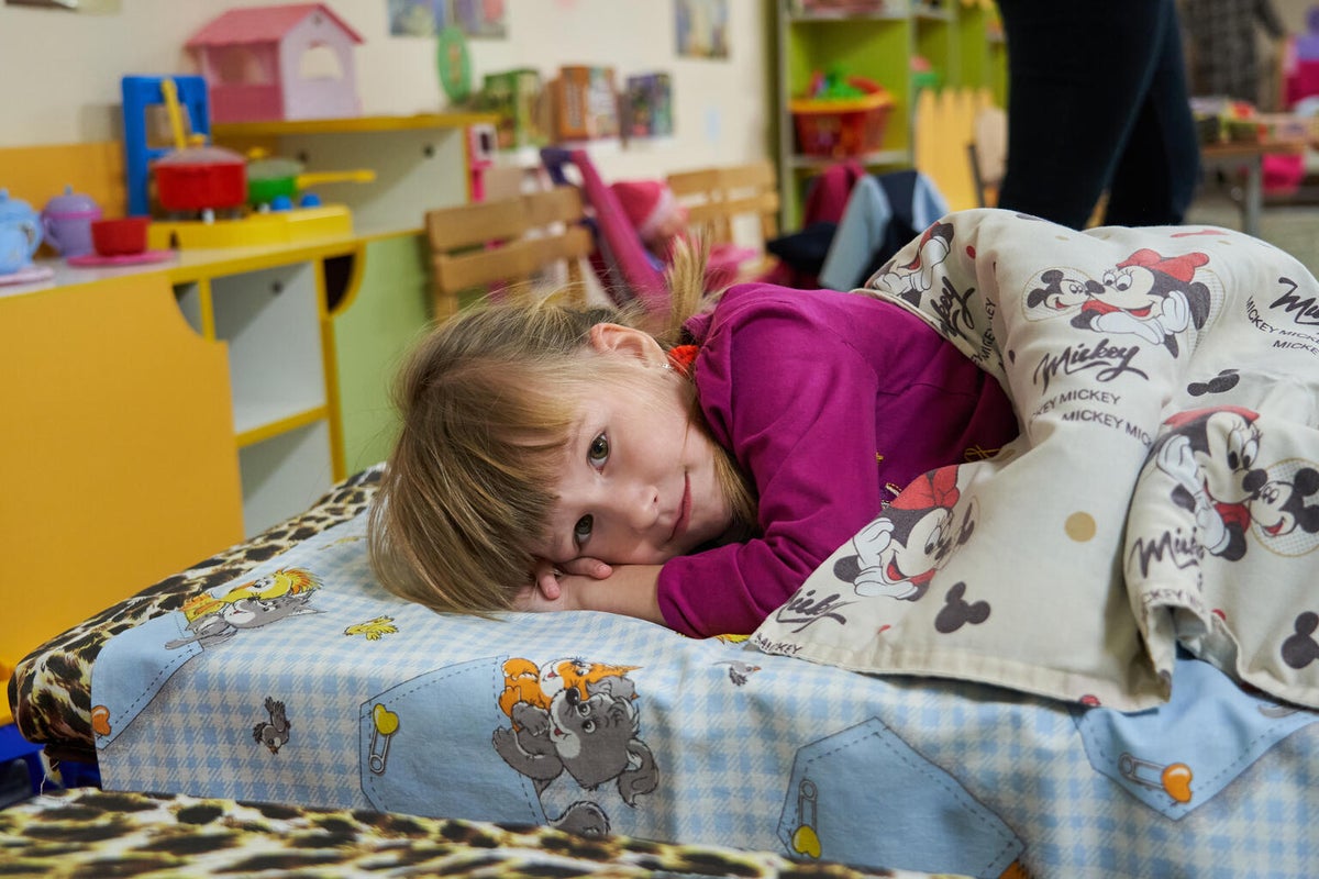 A young Ukraine girl, sleeps in an underground bunker during the day at kindergarten
