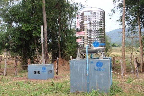 A water tank with pipes running out of it.