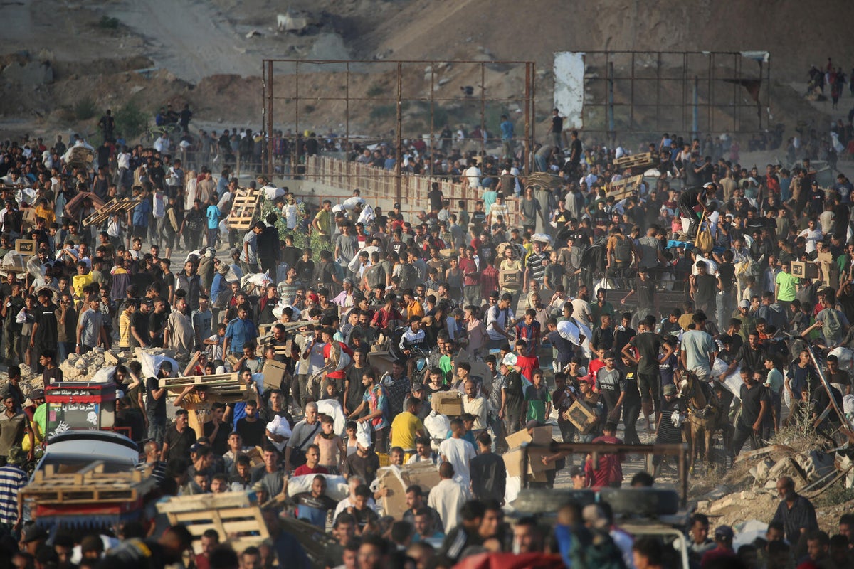 Crowds gather in and around non-UN aid distribution sites.