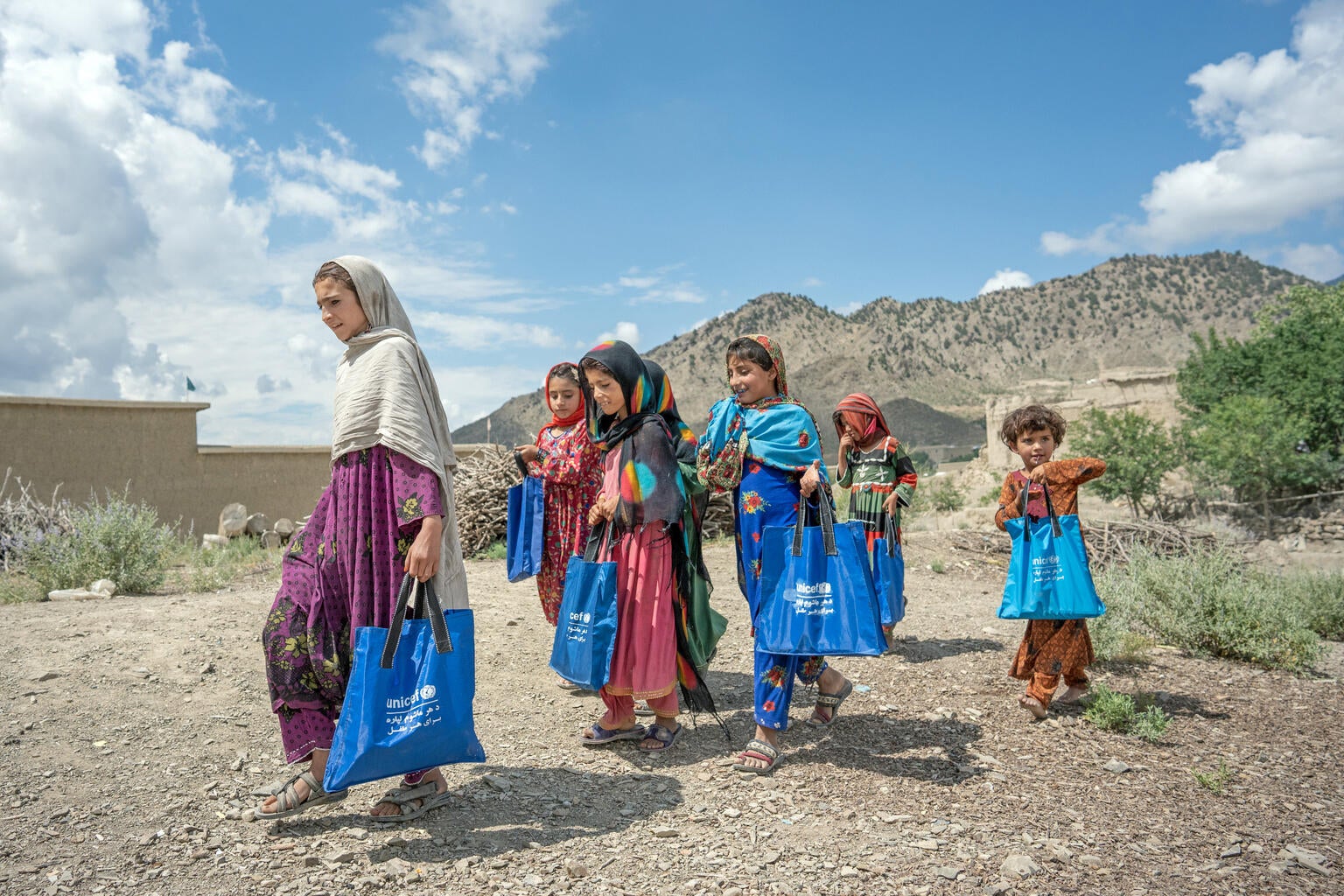 Afghanistan girls walking together along a dirt path