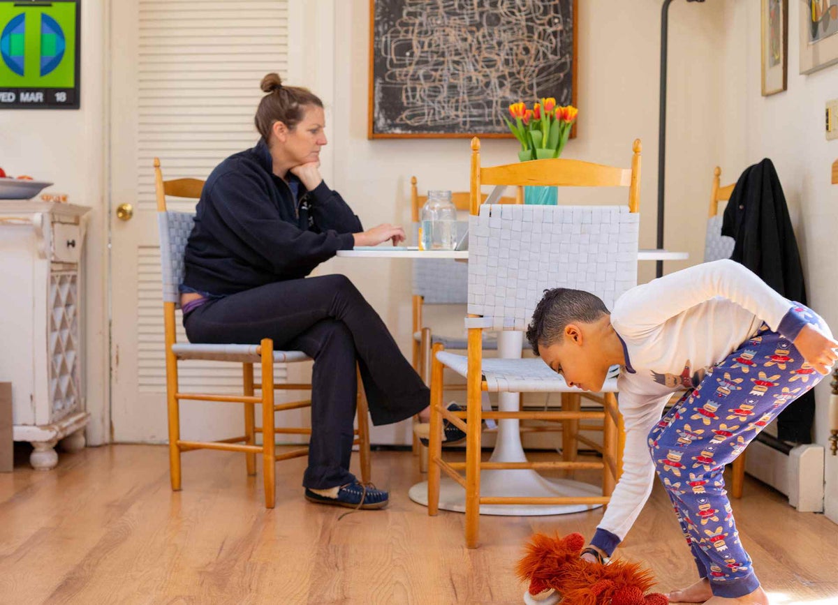 Mothers works while child plays, during lockdown