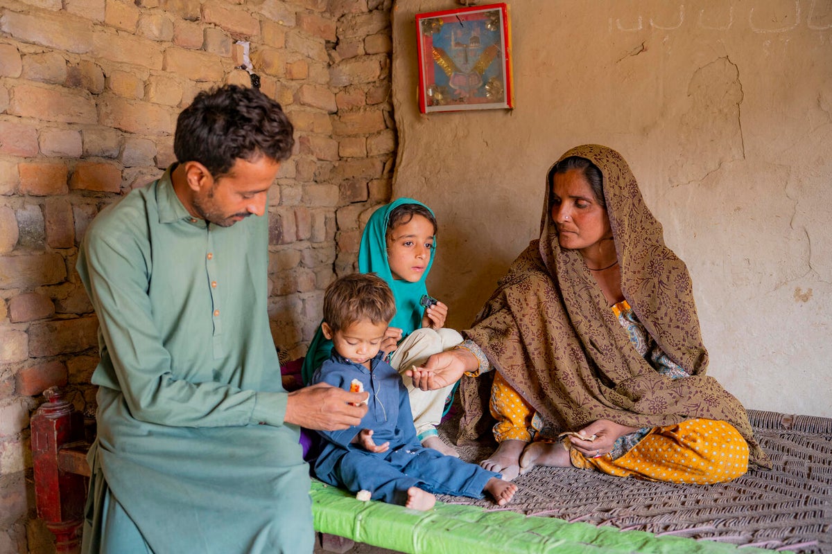 A family sits in their home with their son who is recovering from malnutrition. 