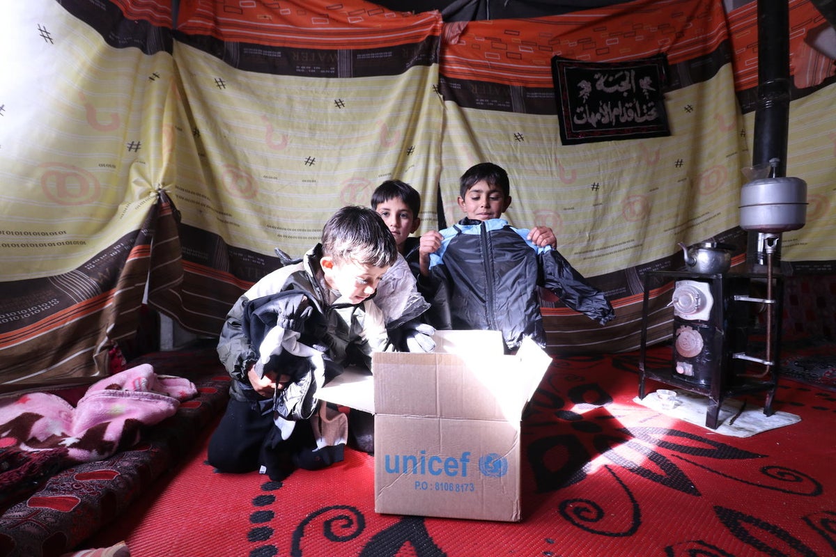 Children look through a box of UNICEF-supported winter supplies in  rural Homs