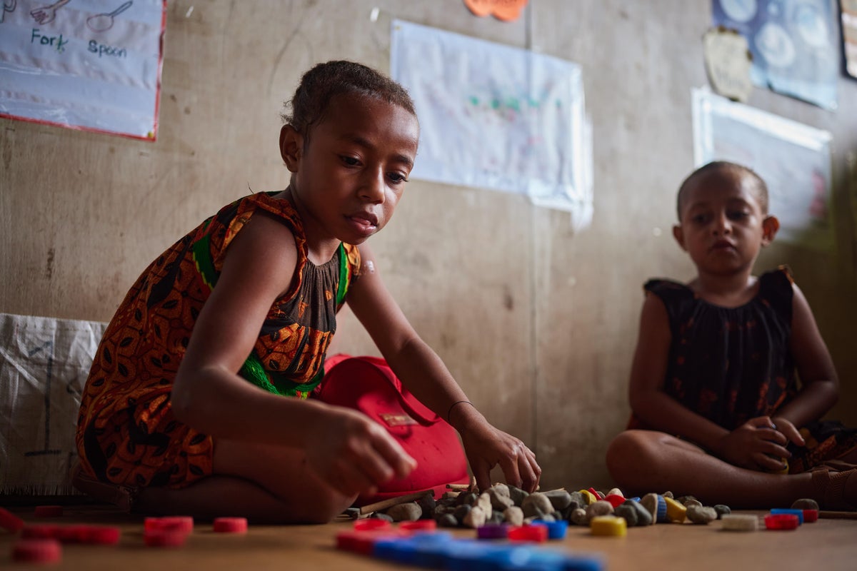 Unable to hear or speak, Phillandrah communicates with one of her teachers, Tane, who is trained in inclusive education in Papua New Guinea.   