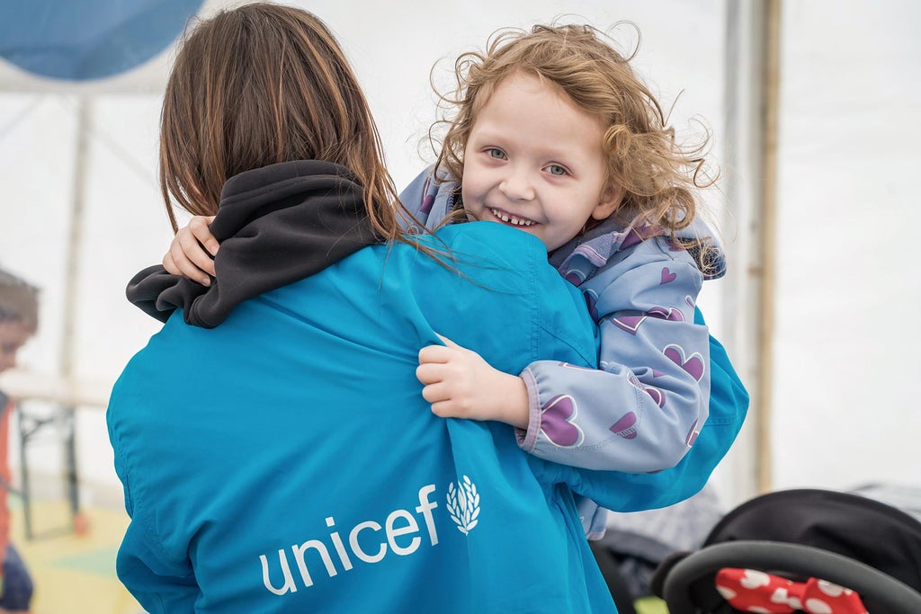 UNICEF staff member and smiling child