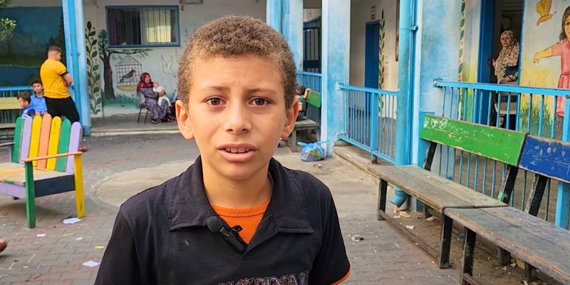 Child standing in playground where they are sheltering during the Gaza crisis