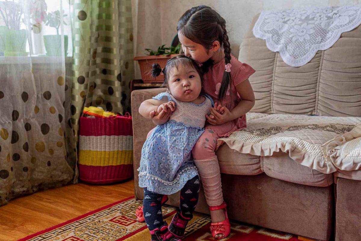 Uuriintsolmon, 1, cuddles with her older sister, Gunjidmaa, 5, at their home in the Khövsgöl Province, Mongolia.