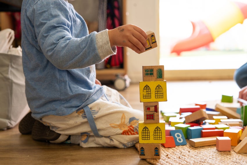 A young boy builds a home out of blocks.