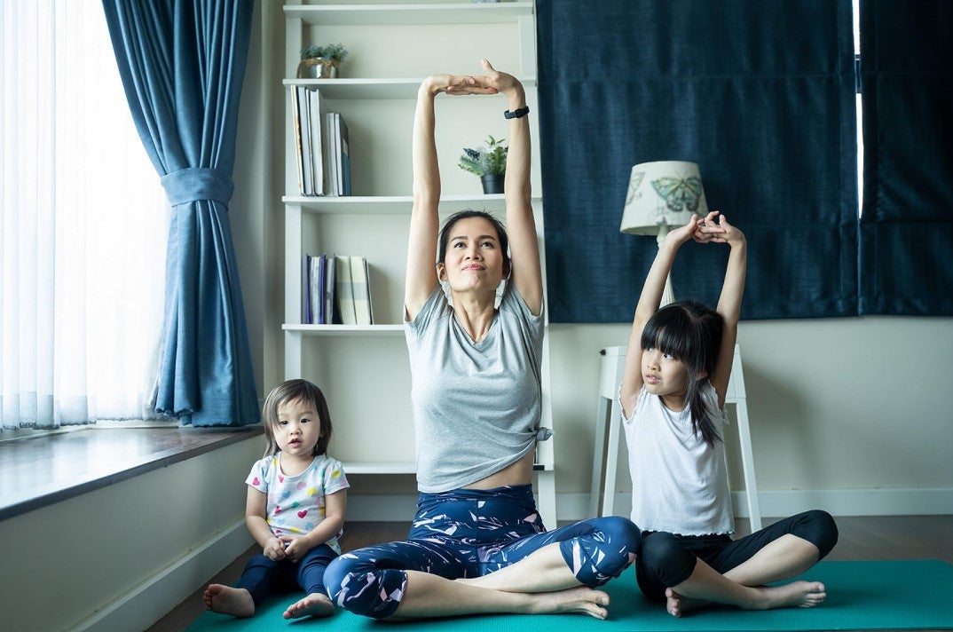 Parent doing yoga in their house. 