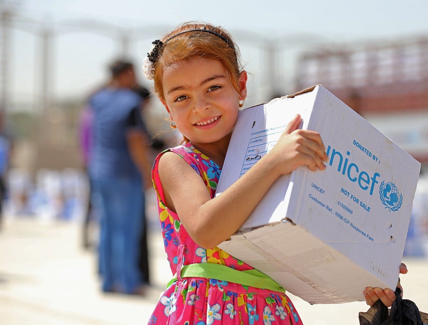 A girl holding a UNICEF box