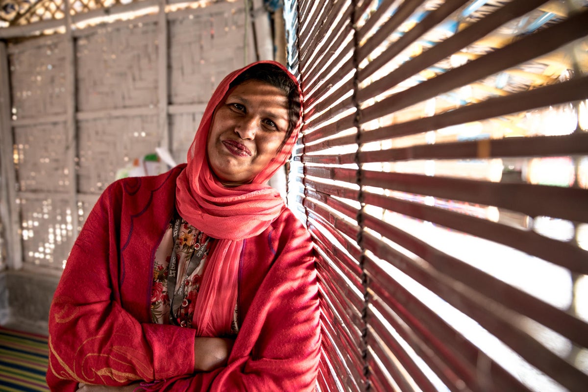 A middle aged woman smiles to the camera