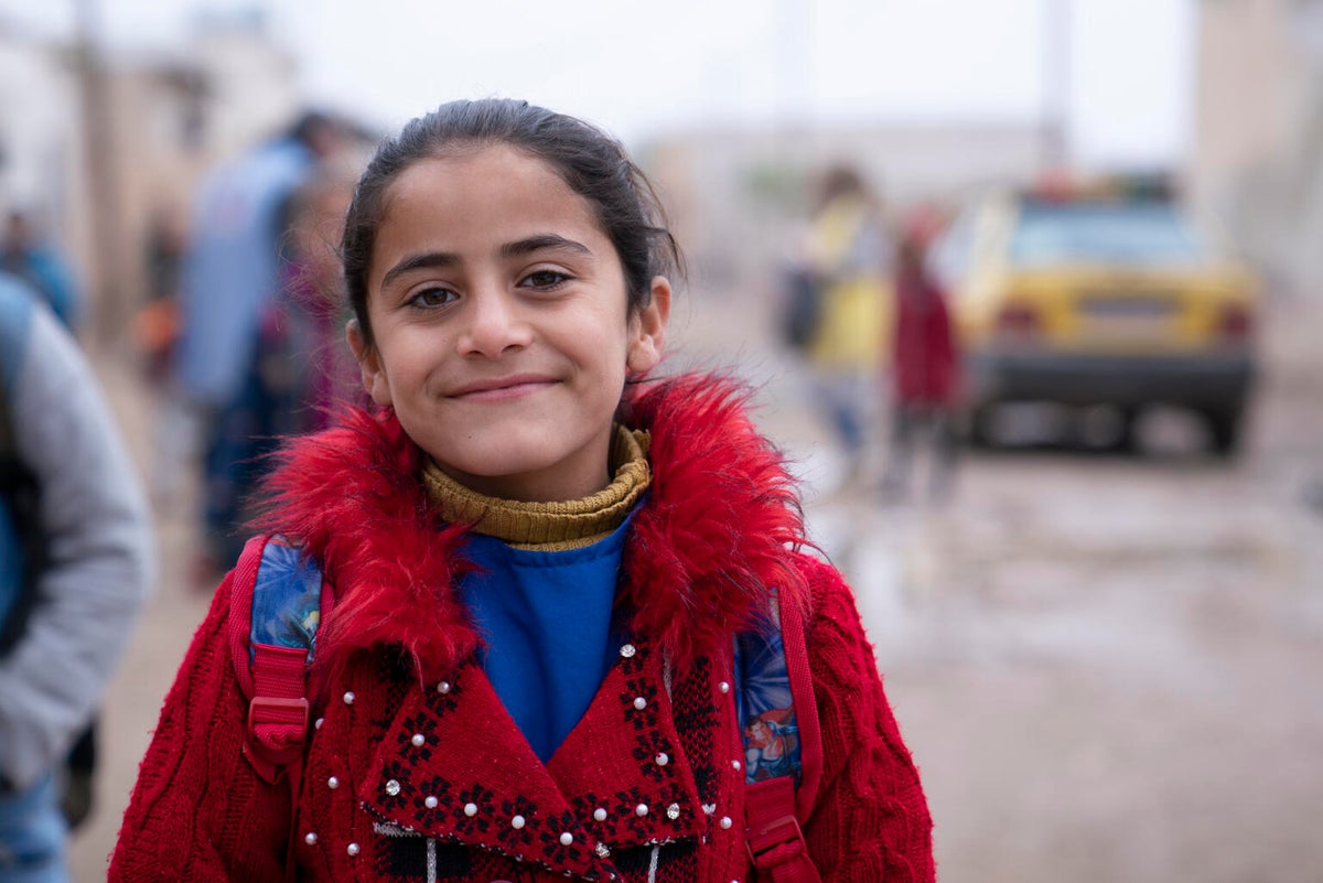 A young Syrian girl smiles at the camera