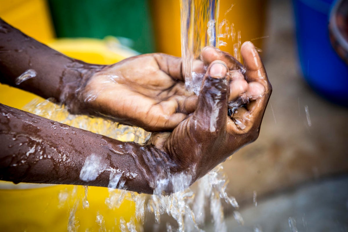 Two hands under a tap with running water.