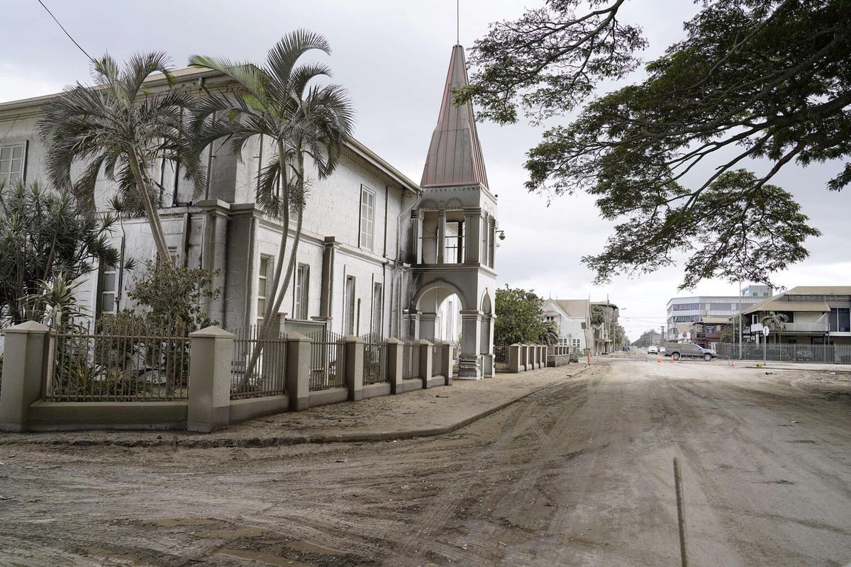 An old big building. The street is covered in ash.