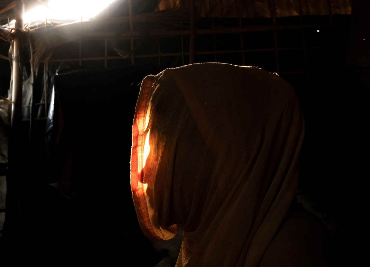 Female with head scarf, sits in the light