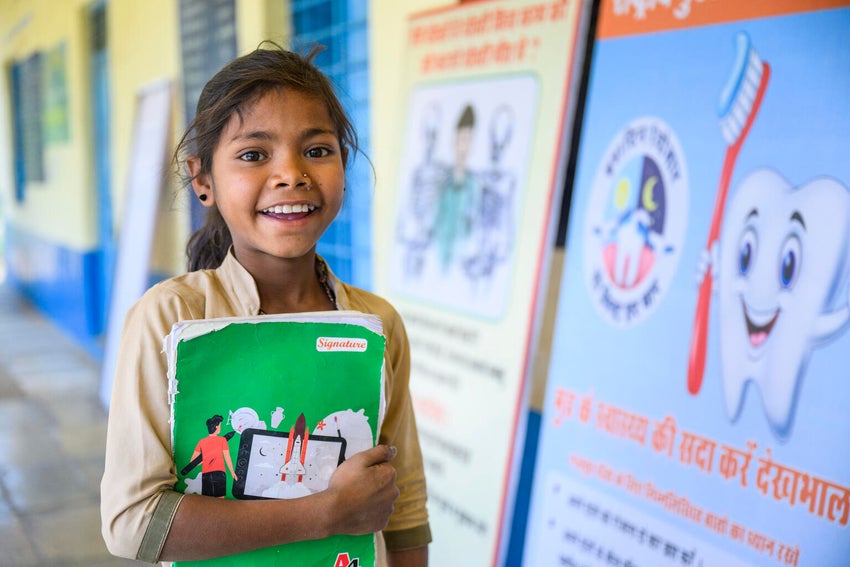 An Indian school girl smiling at the camera